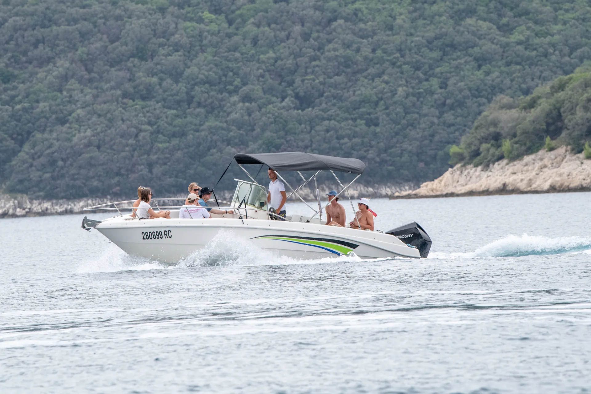 FIART OASSI 22 cruising with a group — green-stripe livery against the coast.