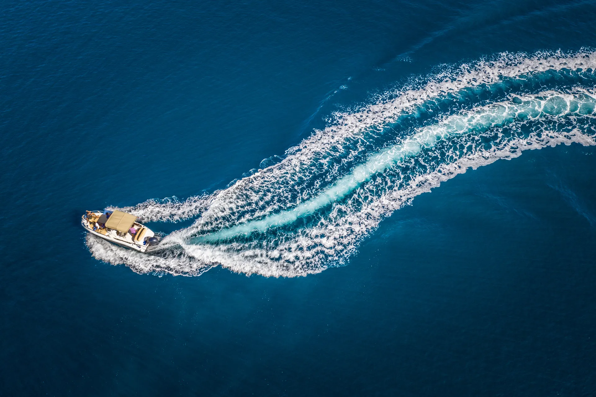 Rabac harbour from the air — a Fru Fru speedboat carving open Adriatic water.